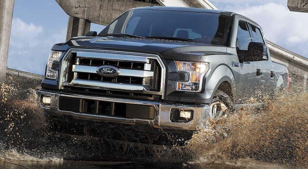 A grey 2018 Ford F-150 is driving to a used truck dealer near DeWitt.