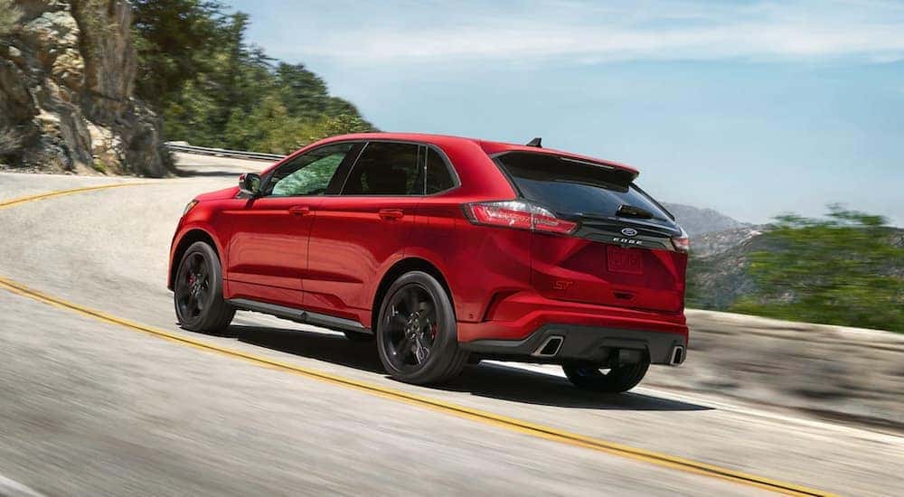 A red 2021 Ford Edge is driving on an open road.