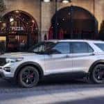 A white 2022 Ford Explorer ST is shown from the side parked in front of a restaurant.