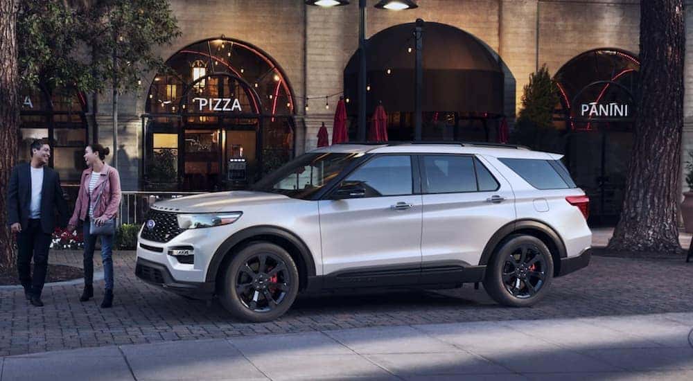 A white 2022 Ford Explorer ST is parked in front of a restaurant.