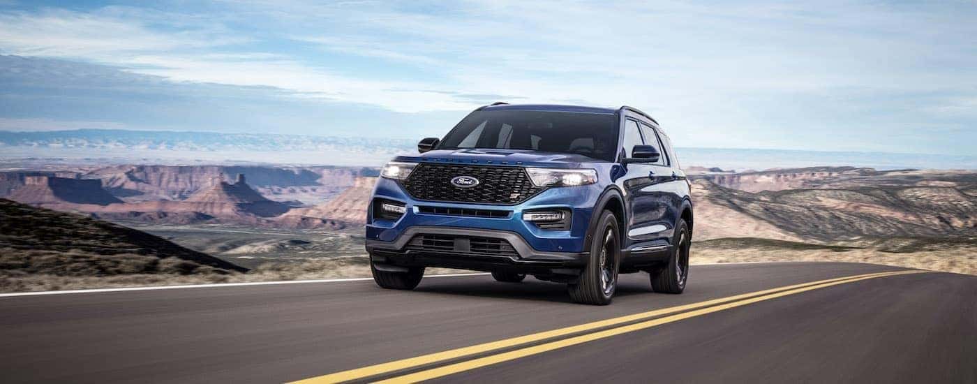 A blue 2020 Ford Explorer ST is driving on an open road.
