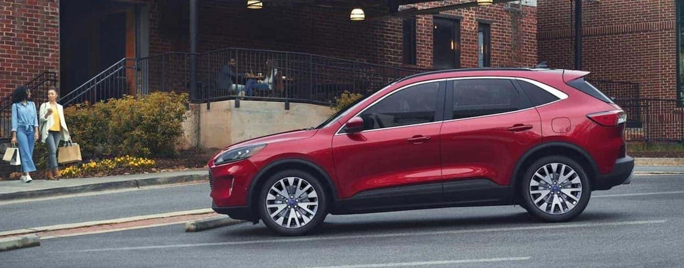 A red 2022 Ford Escape is parked in front of a city building.