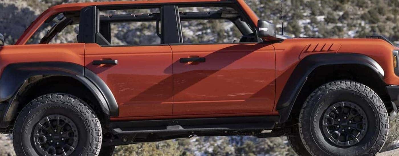 An orange 2022 Ford Bronco off-roading after leaving a Ford dealership in central Michigan.