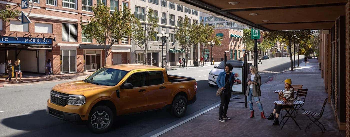 An orange 2022 Ford Maverick parked on a city street.