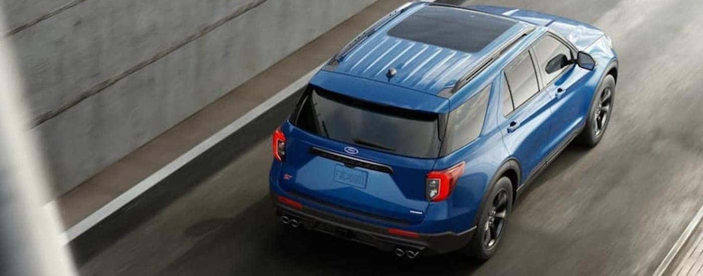 A blue 2020 Ford Explorer driving to a used Ford dealership.