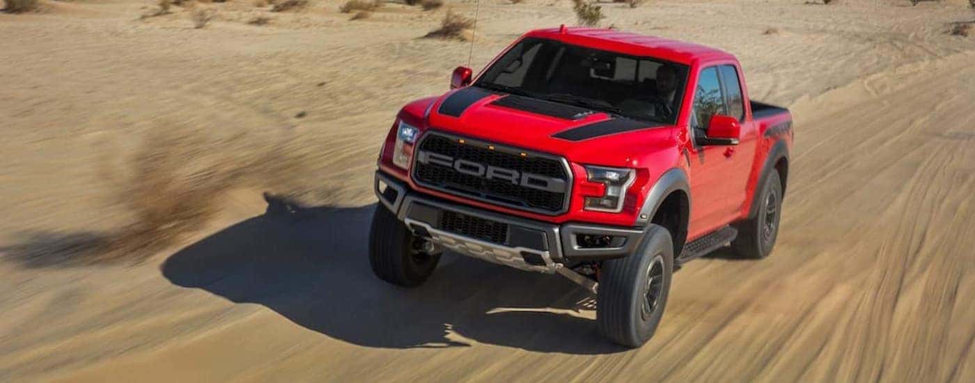 A red 2020 Ford F-150 Raptor is off-roading.