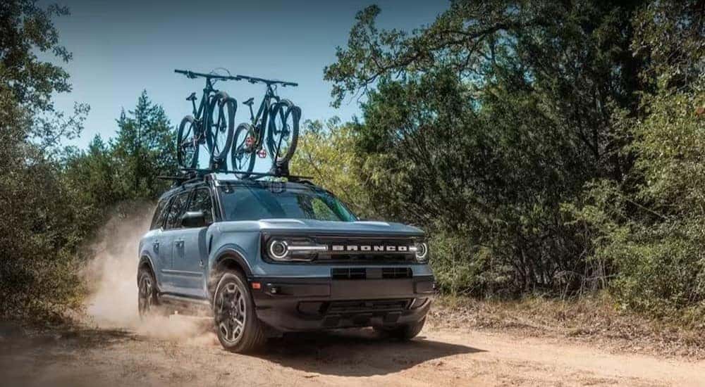 A blue 2023 Ford Bronco Outer Banks is driving off-road.