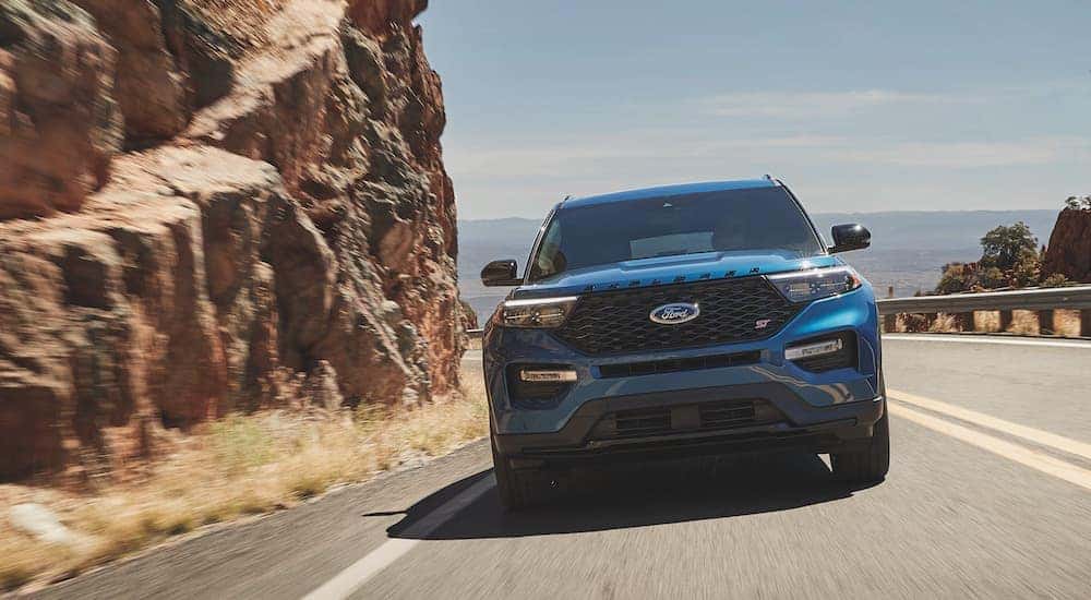 A blue 2021 Ford Explorer ST is driving on a highway.