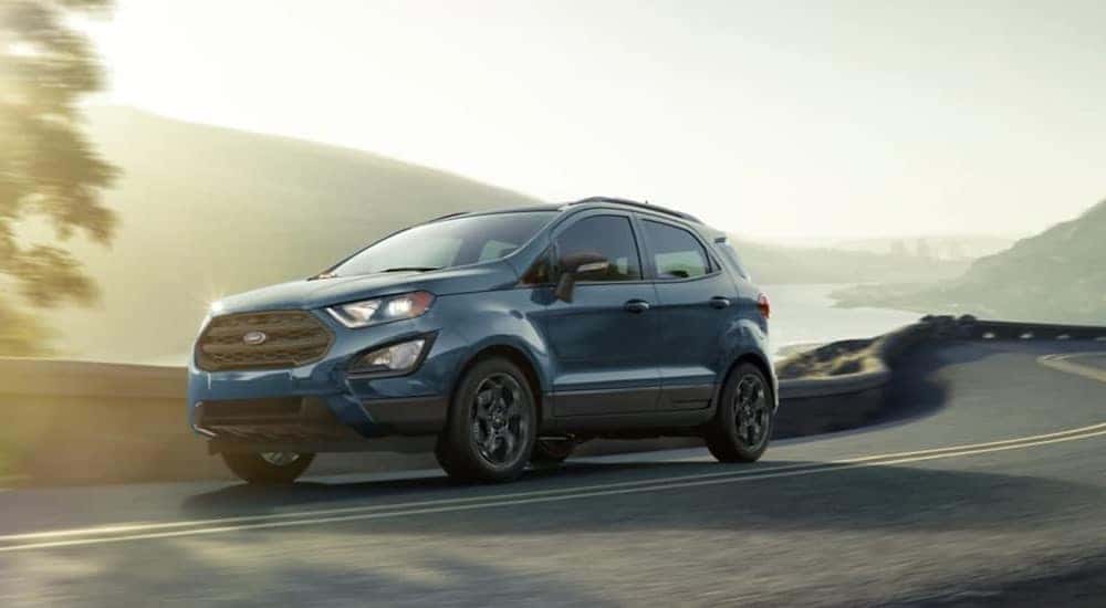 A blue 2021 Ford EcoSport is driving to a used car dealer near Owosso.
