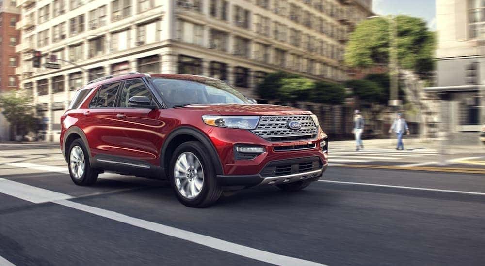A red 2020 Ford Explorer driving through a city.