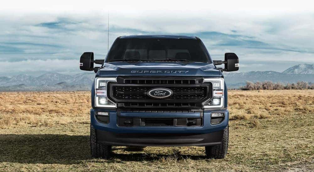A blue 2021 Ford F-250 parked in a field.