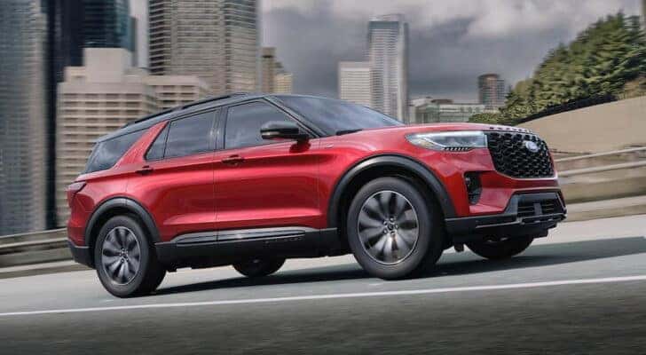 A red 2025 Ford Explorer ST-Line driving in a city.