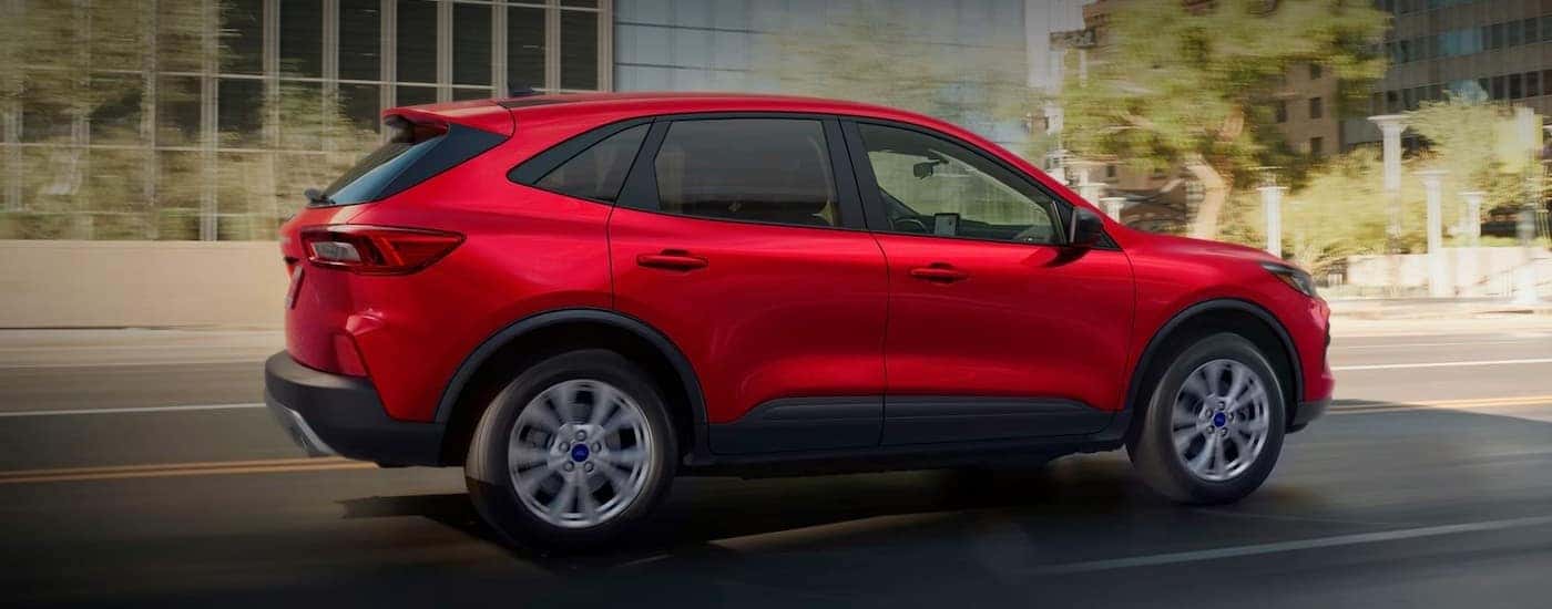 A red 2025 Ford Escape for sale near Grand Ledge driving in a city.