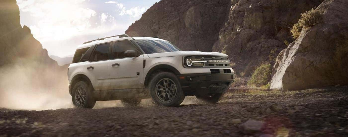A white 2022 Ford Bronco Sport for sale is driving off-road.