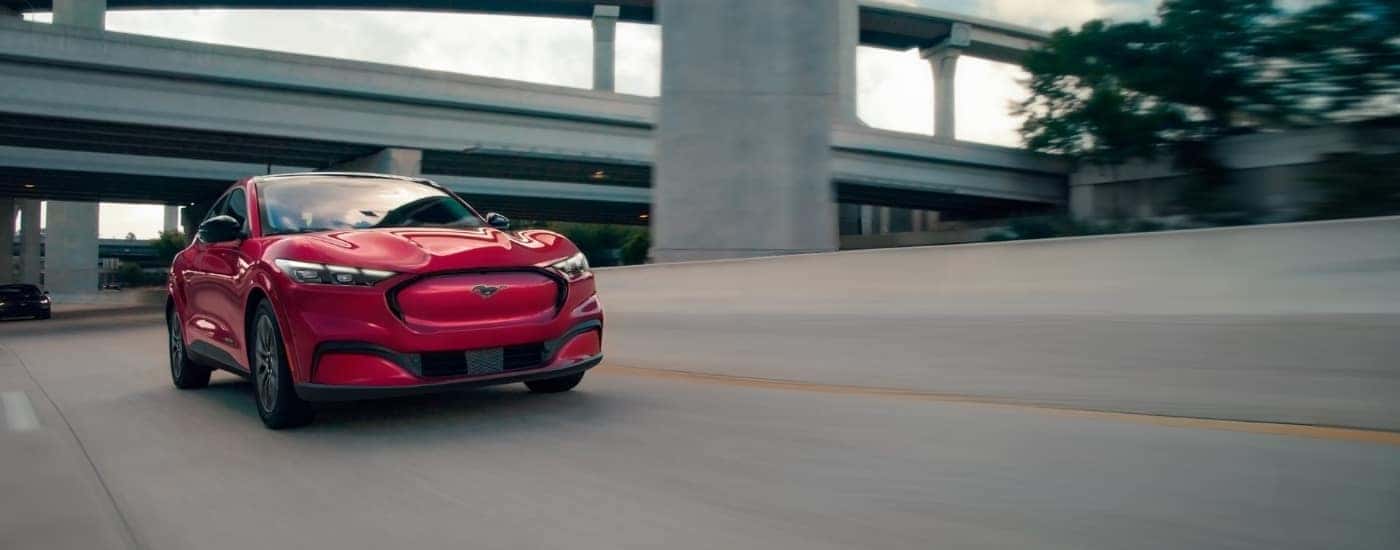 A red 2025 Ford Mustang Mach-E driving to a Ford dealer near you.