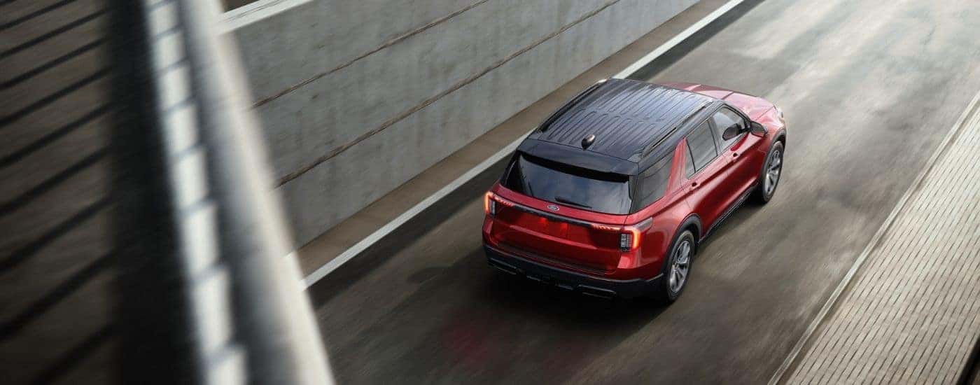A red 2025 Ford Explorer driving in a city.