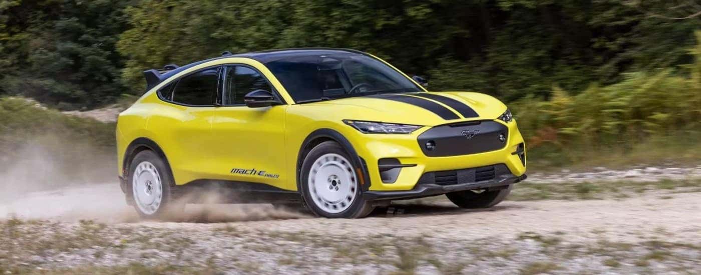A yellow 2024 Ford Mustang Mach-E Rally Edition is parked off-road.