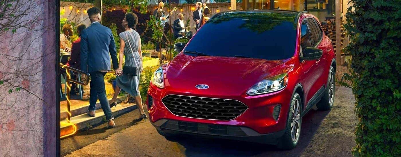 A red 2022 Ford Escape is parked in front of a modern house.