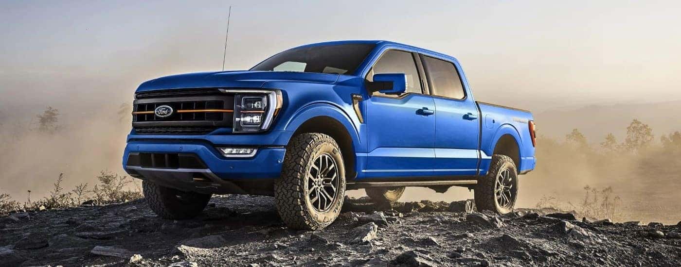 A blue 2023 Ford F-150 Tremor is parked off-road after looking looking at trucks for sale.