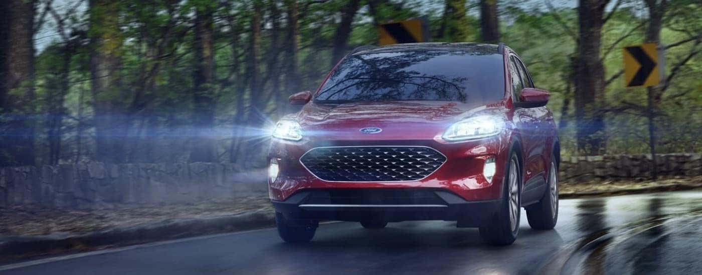 A red 2022 Ford Escape is driving on an open road at dusk.