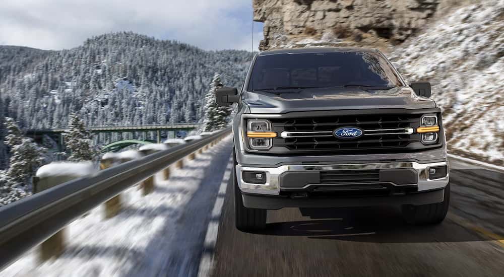 Grey 2024 Ford F-150 driving down a mountain road.