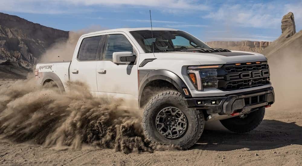 A white 2024 Ford F-150 Raptor off-roading.