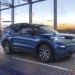 A blue used 2023 Ford Explorer driving on a bridge