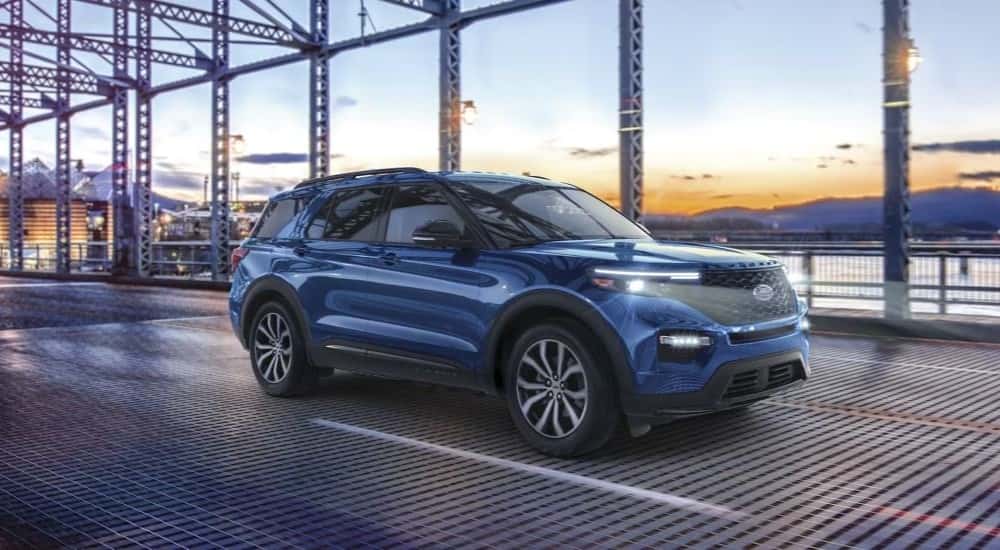 A blue used 2023 Ford Explorer driving on a bridge