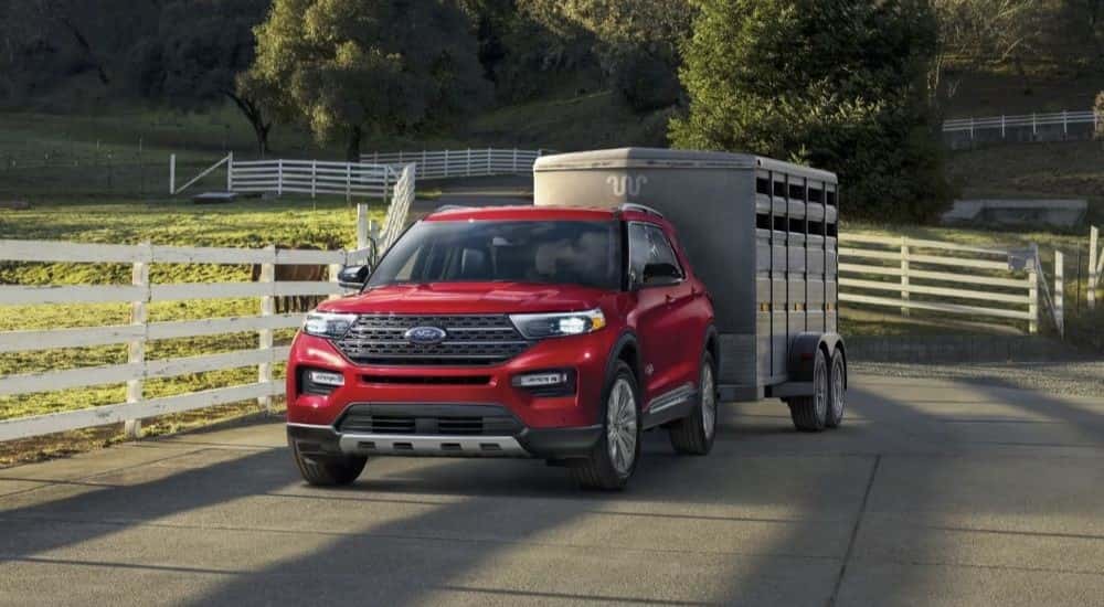A red 2023 Ford Explorer towing a trailer.