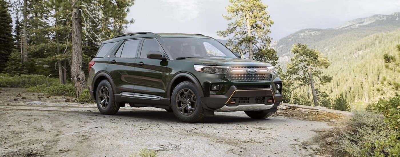 A green used 2023 Ford Explorer Timberline parked off-road in the woods
