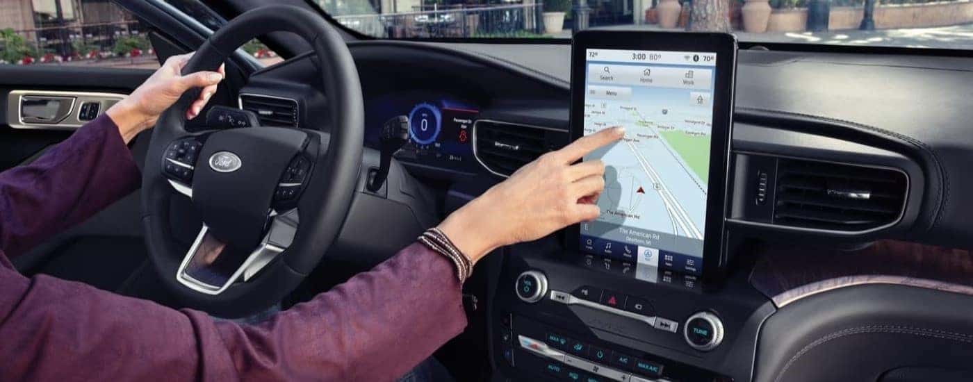 A woman using an infotainment display on a used 2023 Ford Explorer for sale