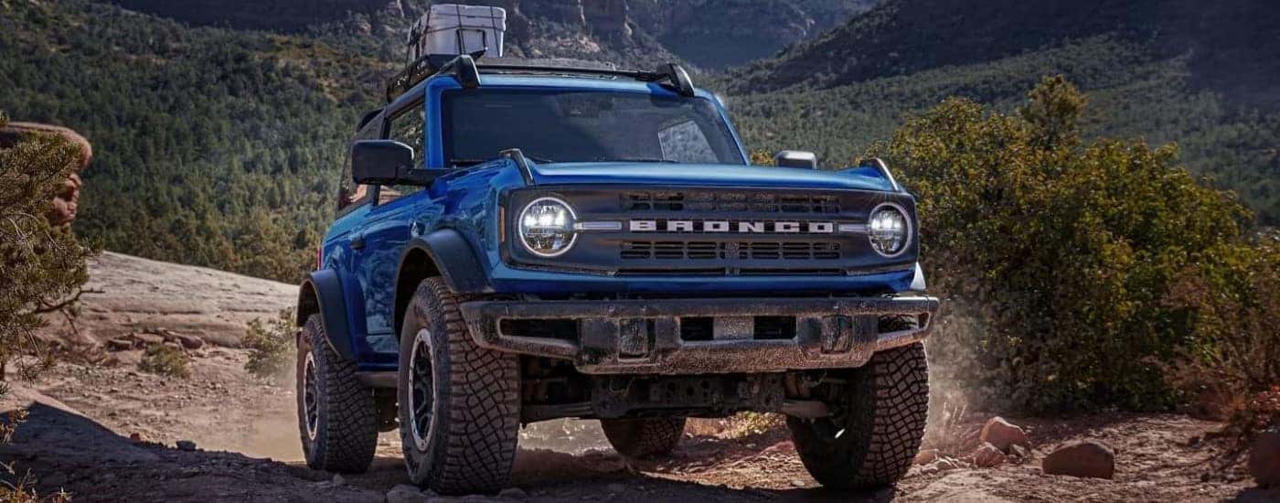 Blue 2025 Ford Bronco driving off-road.