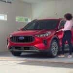 A red 2023 Ford Escape parked in a garage.