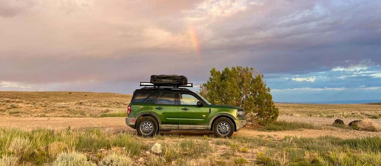 Green 2025 Ford Bronco Sport from the side driving across a field.