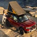 A person climbs into the roof top tent on their 2025 Ford Bronco Sport Badlands.