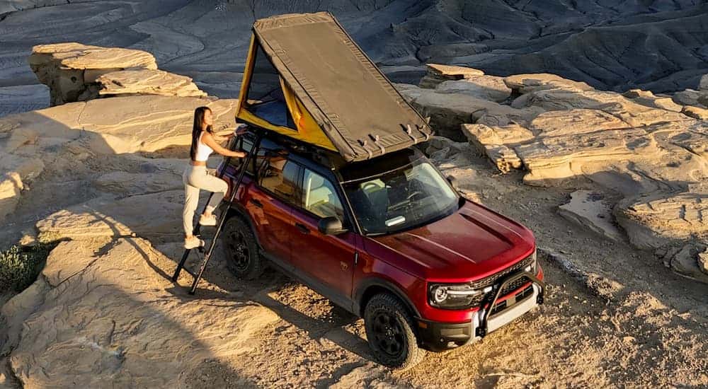 A person climbs into the roof top tent on their 2025 Ford Bronco Sport Badlands.