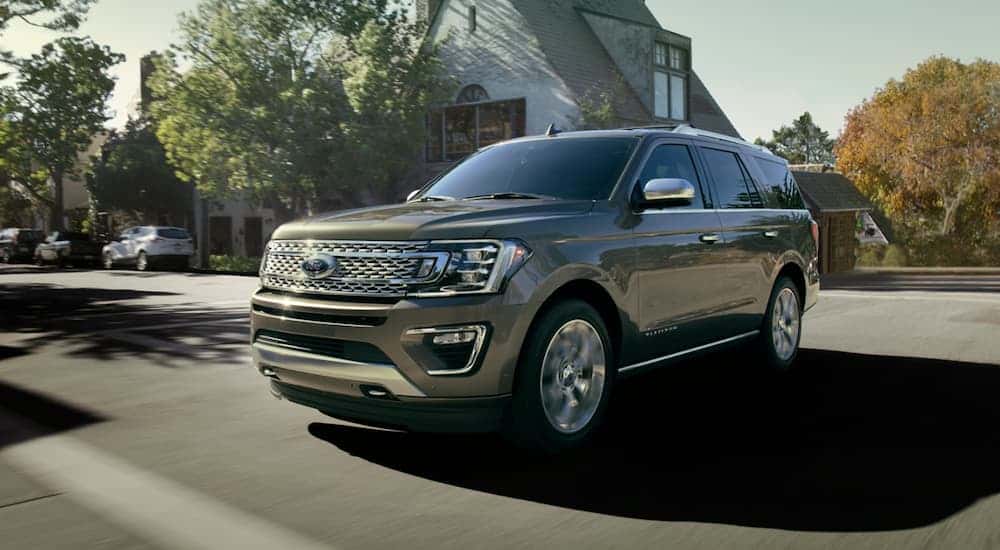 Brown 2020 Ford Expedition driving down a street after looking at used Fords for sale
