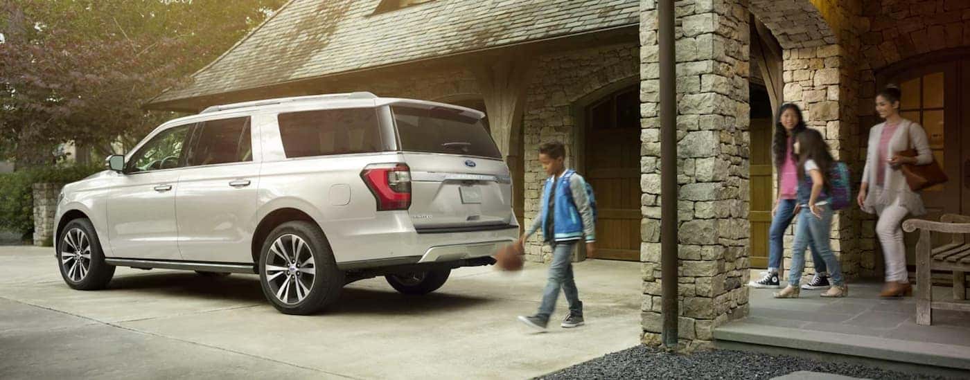 A family walks to a white 2021 Ford Expedition