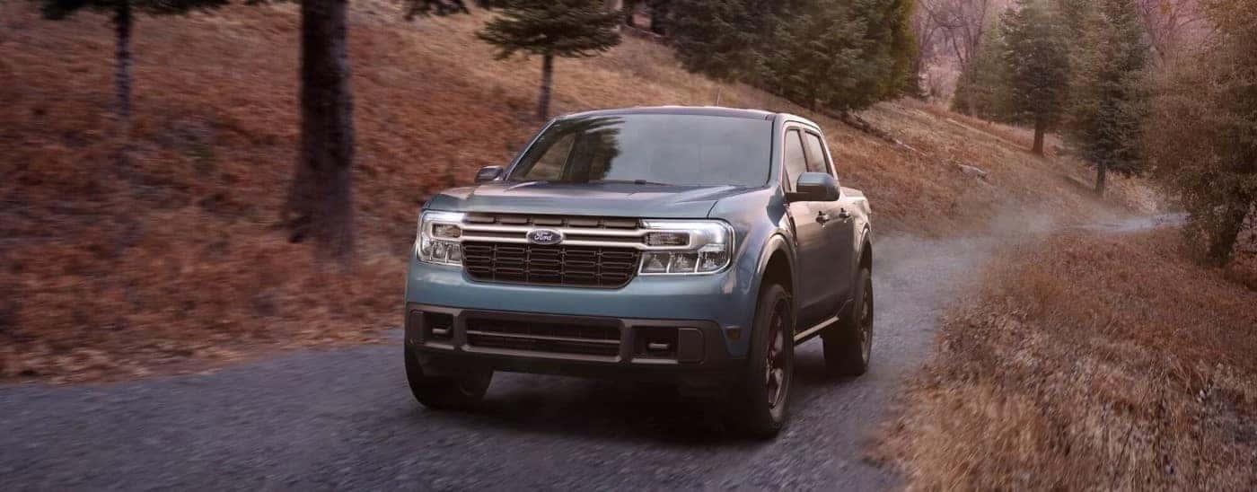 Blue 2023 Ford Maverick driving on a rural road