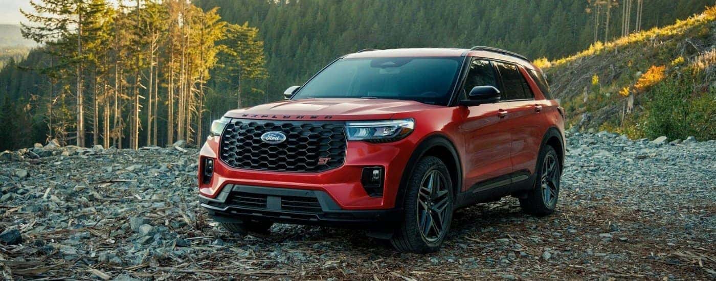 A red 2025 Ford Explorer from the front at an angle after leaving a dealer with SUVs for sale.