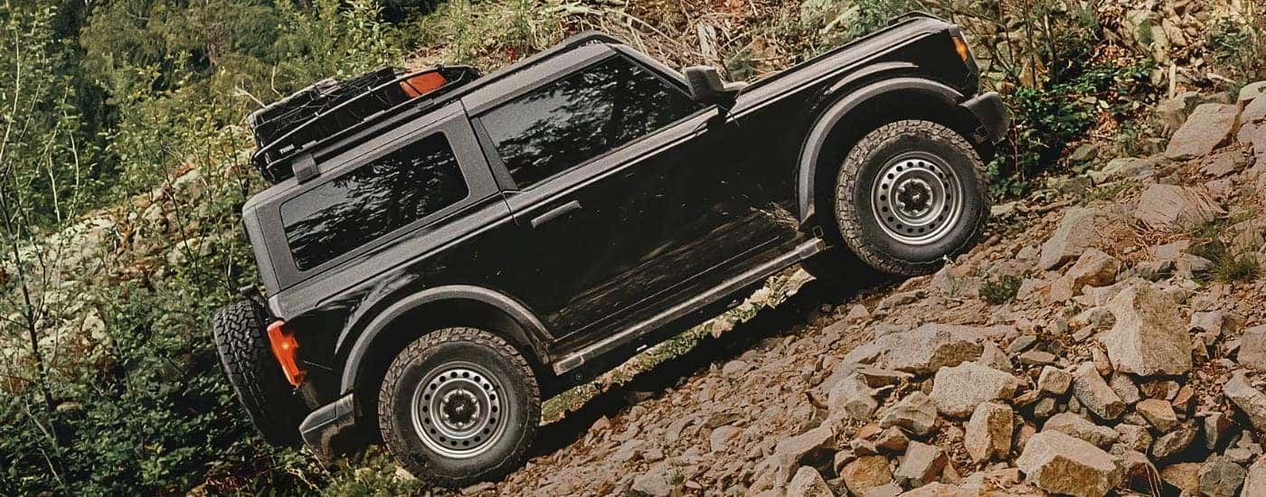 Black 2025 Ford Bronco driving up a hill