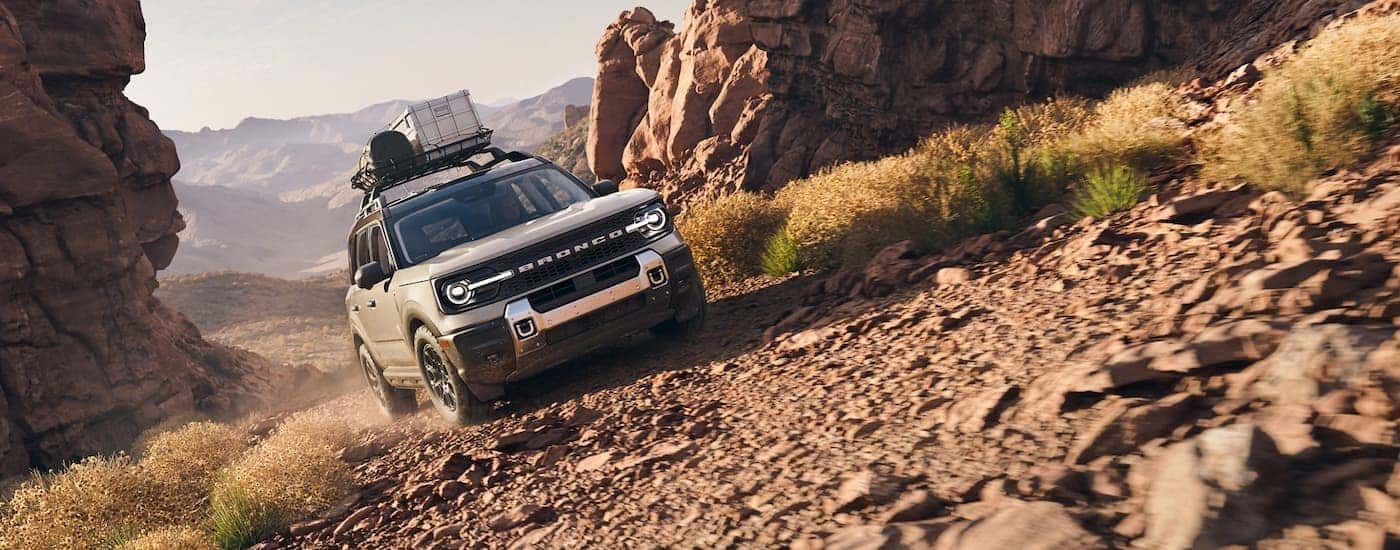 White 2025 Ford Bronco Sport driving off-road up a hill.
