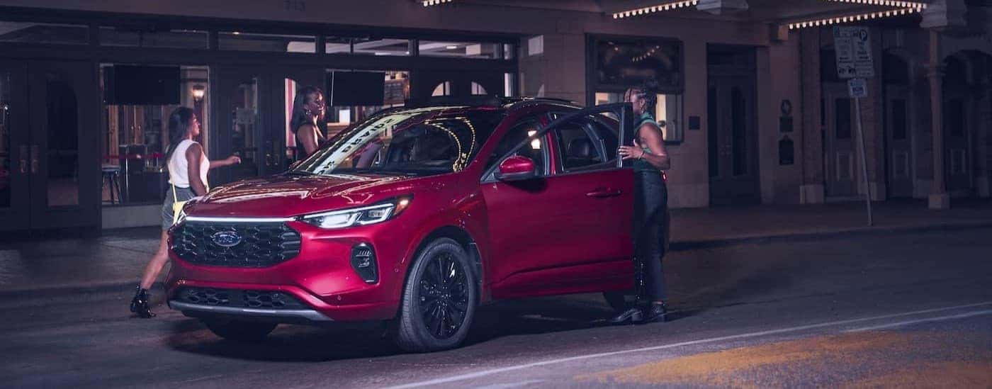 A red 2024 Ford Escape parked at night.