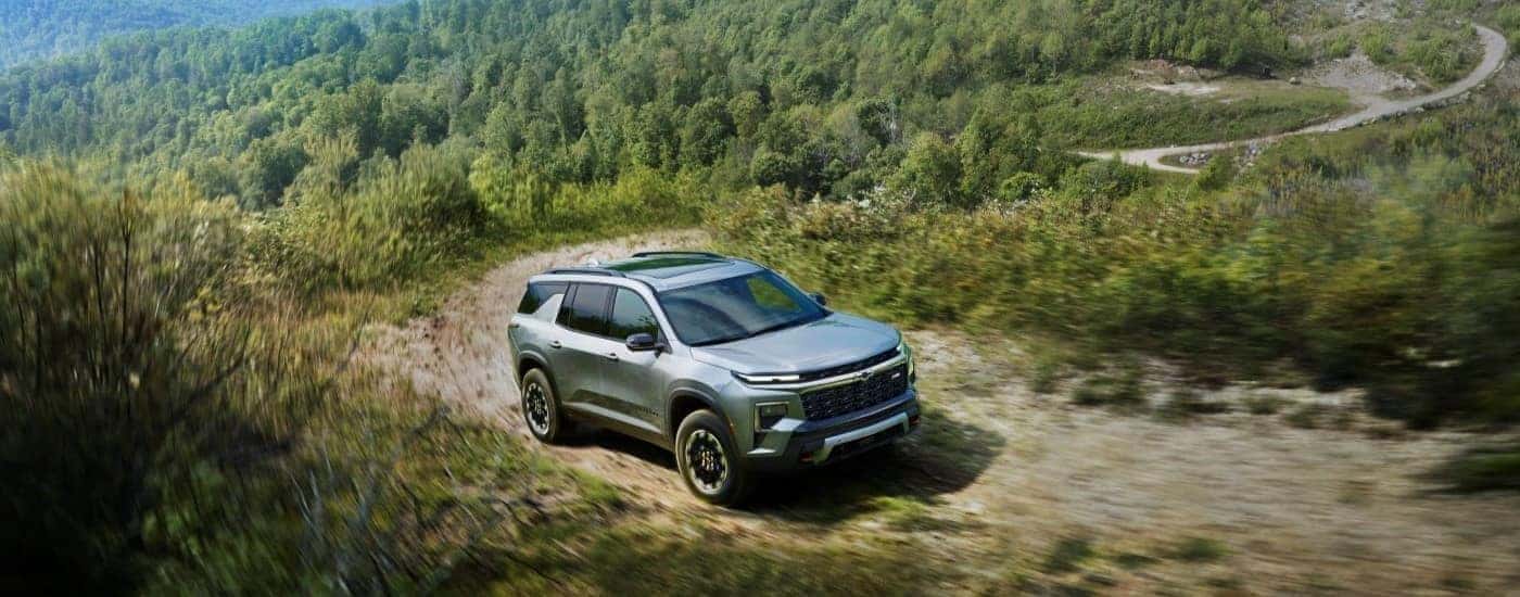 Silver 2026 Chevy Traverse driving up a trail