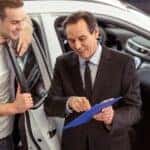 Salesman and customer evaluating a trade in