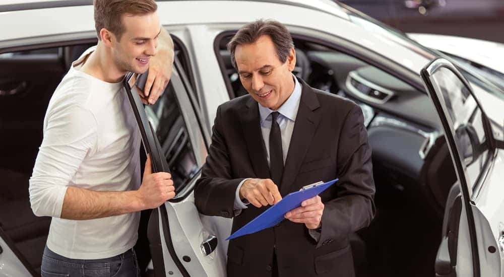 Salesman and customer evaluating a trade in