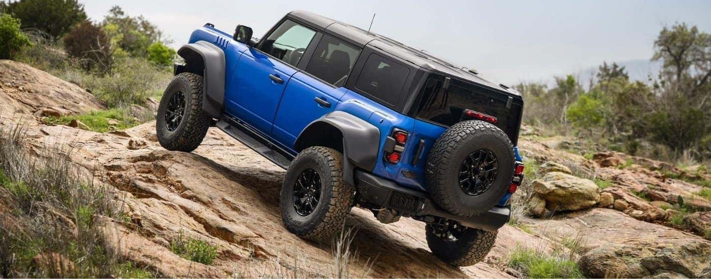Blue 2025 Ford Bronco Raptor driving off-road