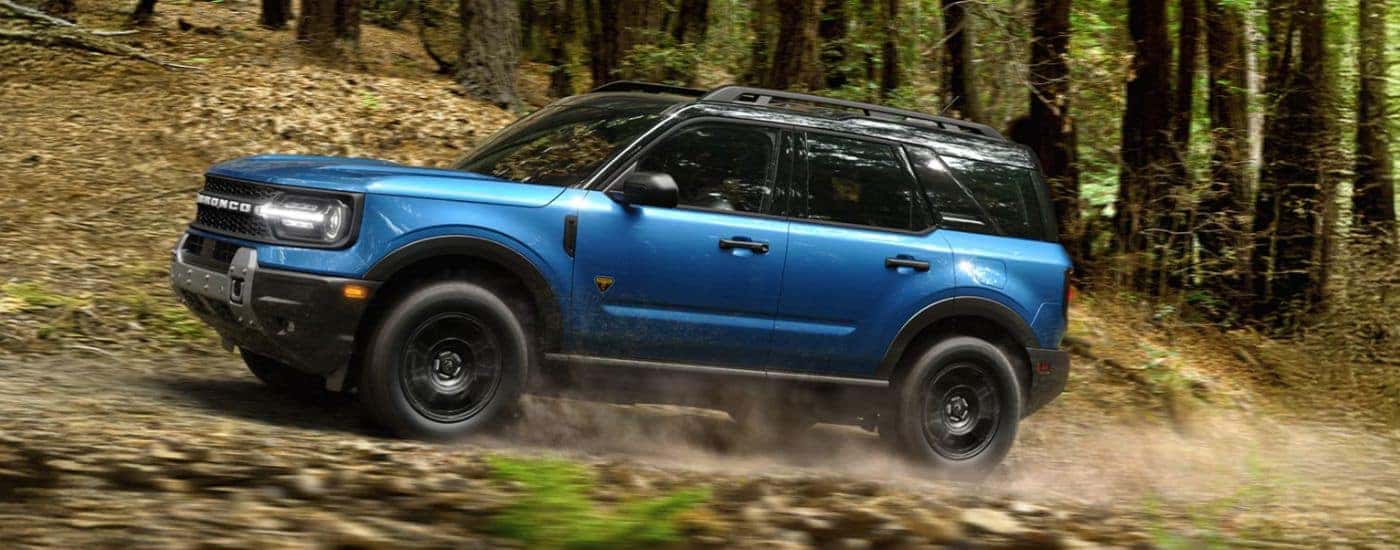 Blue 2026 Ford Bronco Sport driving through the woods