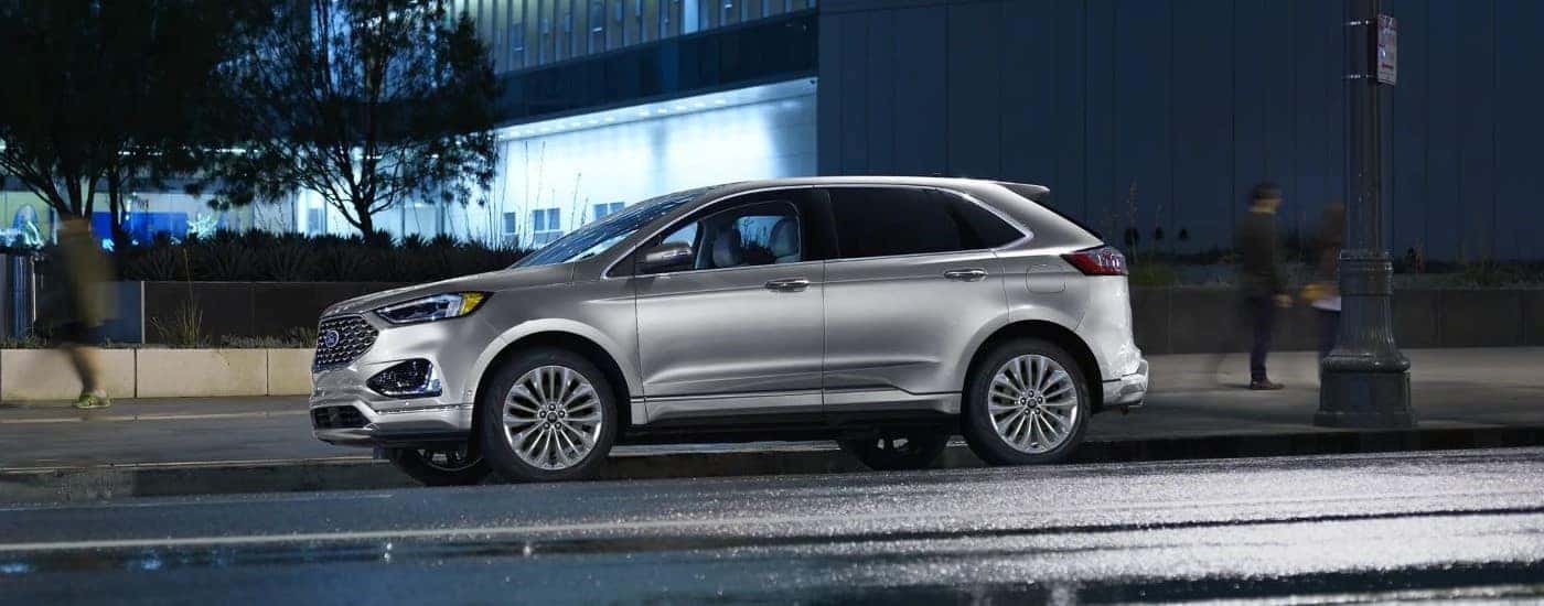 A silver 2023 Ford Edge parked at night.