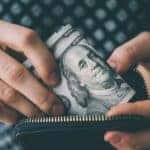 A person is shown holding cash.